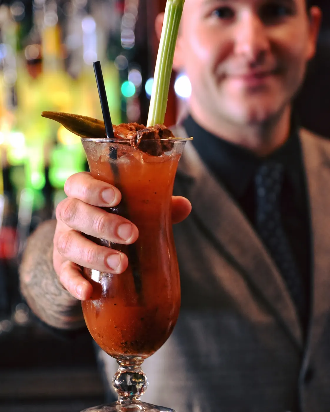 Bartender presenting a Bloody Mary cocktail